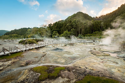 Scenic view of hot spring against sky