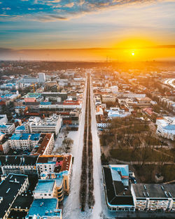 High angle view of city street and buildings against sky during sunset