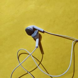 Low angle view of electric fan against yellow wall