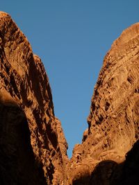 Low angle view of rock formation against clear blue sky