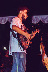 Midsection of man playing guitar