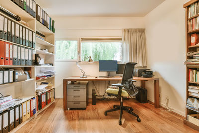 Rear view of woman sitting on shelf at home