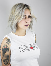 Portrait of young woman standing against white background