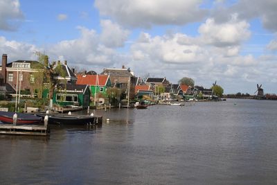 Sailboats moored in sea against buildings in city