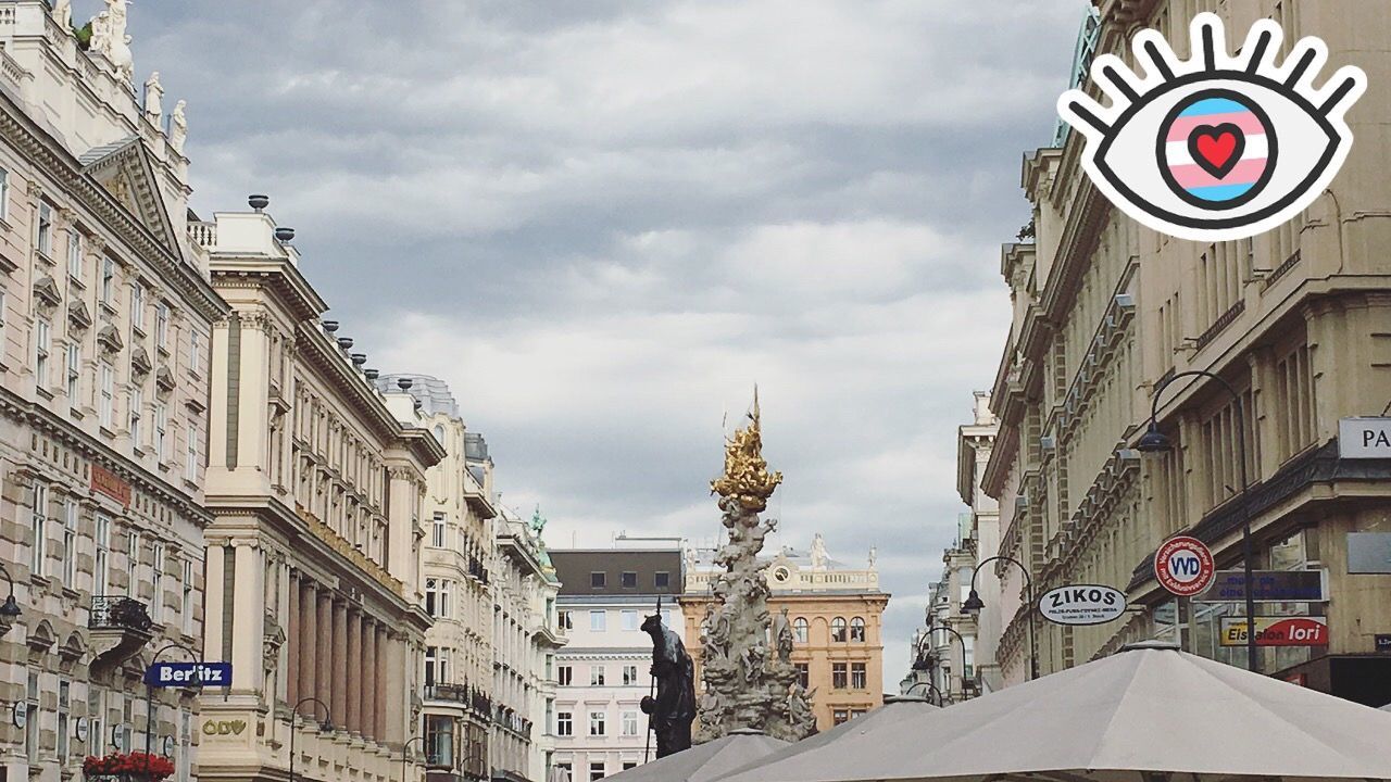 STATUE AMIDST BUILDINGS IN CITY AGAINST SKY