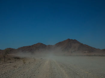 Scenic view of desert against clear blue sky