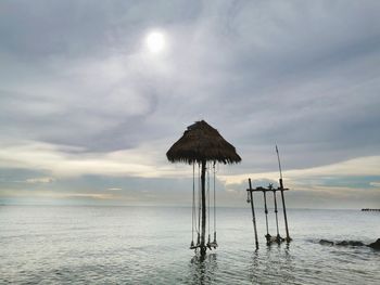 Lifeguard hut on beach against sky during sunset