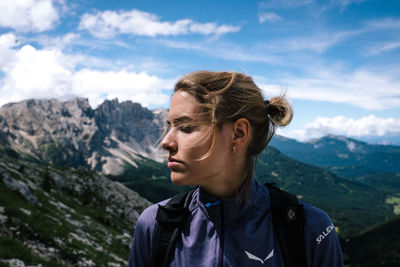 Close-up of young woman looking away against sky