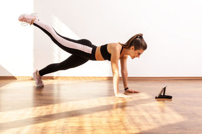 Full length of woman exercising in gym