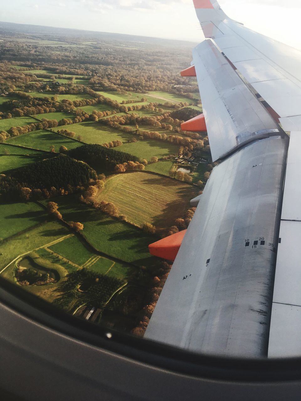 AERIAL VIEW OF AIRPLANE WING ABOVE LANDSCAPE