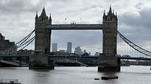 View of tower bridge over river against cloudy sky