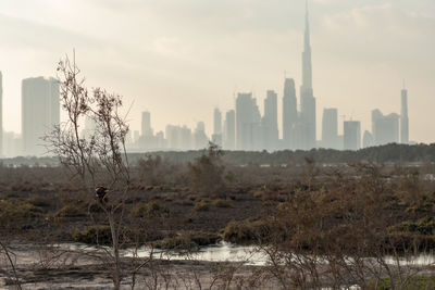 Scenic view of river by buildings against sky