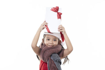 Portrait of girl holding red umbrella against white background