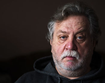 Portrait of mature man against black background