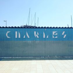 Information sign against clear blue sky