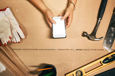 Cropped hands of woman using mobile phone