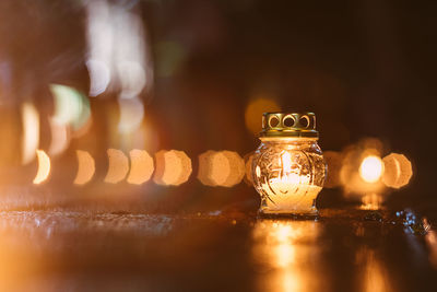 Close-up of illuminated candle on table