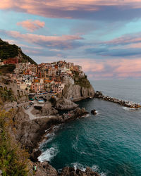 Scenic view of sea by buildings against sky