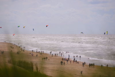 People enjoying on beach against sky