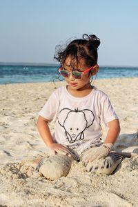 Boy wearing sunglasses on sand at beach