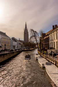 Canal amidst buildings against sky in city