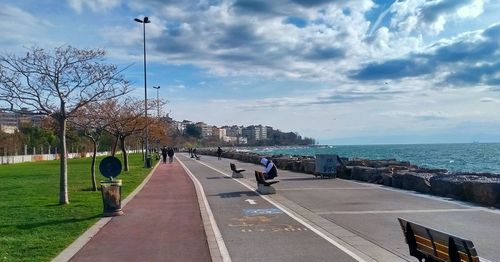 Road by sea against sky in city