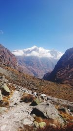 Scenic view of snowcapped mountains against blue sky