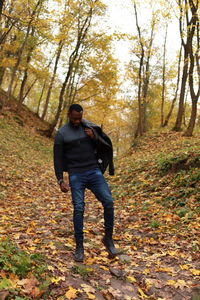 Full length of young man standing in forest