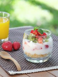 Fruit yoghurt with juice on table in yard