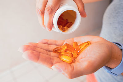 Midsection of woman holding pills