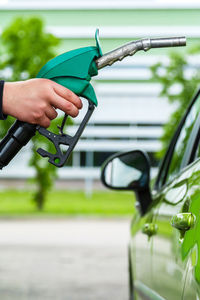 Cropped hand of man filling gasoline in car