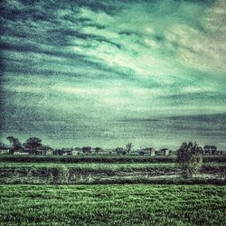 Scenic view of field against cloudy sky