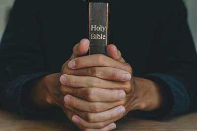 Midsection of man holding text on table