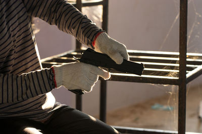 Midsection of man holding gun