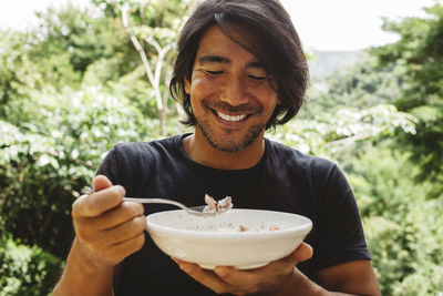 Smiling man having breakfast in yard