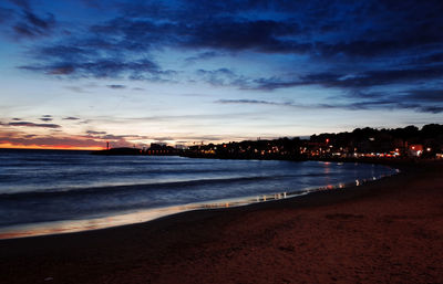 Scenic view of beach against sky at sunset