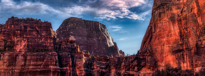 Low angle view of rocks against cloudy sky