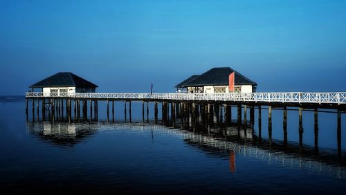 Built structure by sea against blue sky