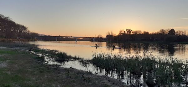 Scenic view of lake against clear sky during sunset