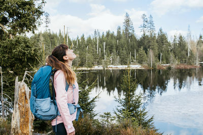 A young girl with a sports backpack on her back enjoys nature. a woman stands and inhales 