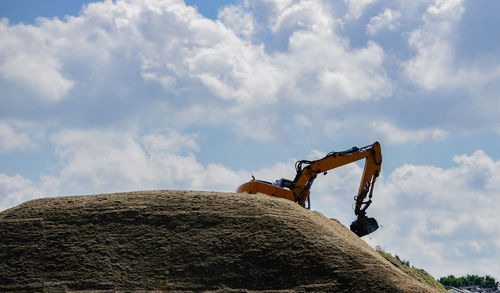 Crane on construction site against sky