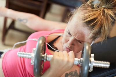 Determined disabled woman lifting weights at home