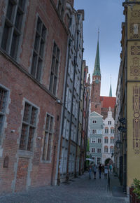 People walking on street amidst buildings in city