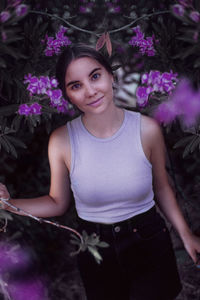 Portrait of young woman sitting on christmas tree