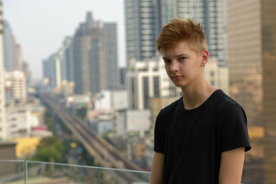Portrait of young man looking at city