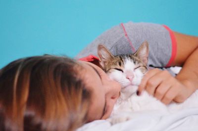 Woman with cat lying on bed