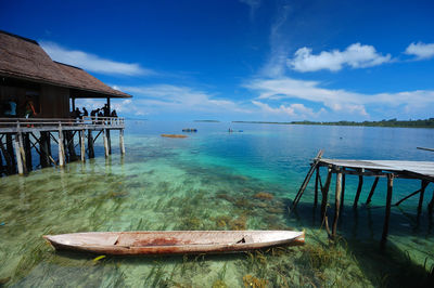 Boat in sea by pier against sky