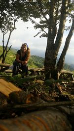 Woman sitting on tree