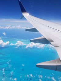 Close-up of airplane wing against blue sky