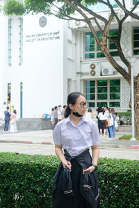 Portrait of young woman standing on street